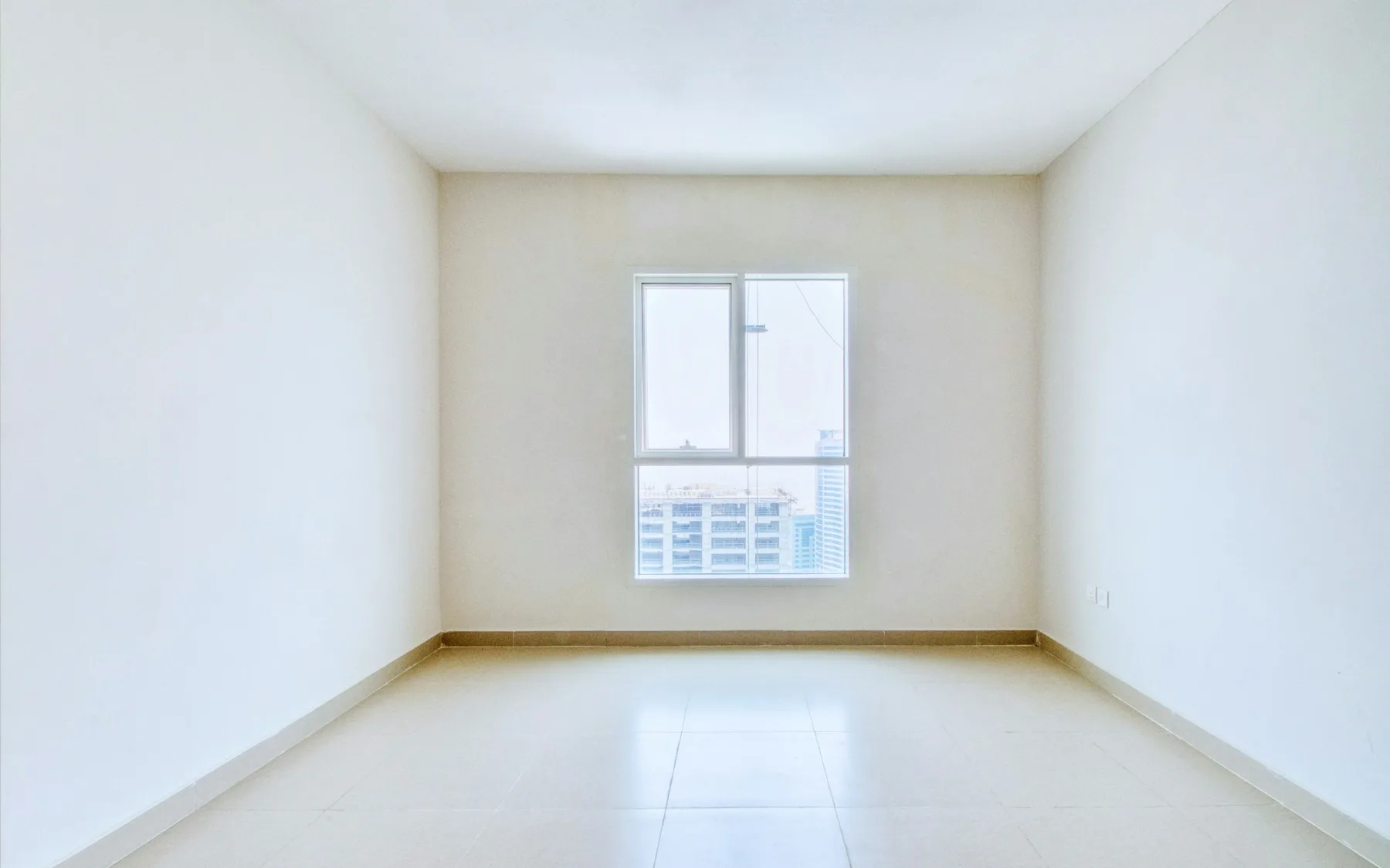 Încăpere goală de apartament, fotografiată cu unghi larg, verticale drepte, lumină de geam