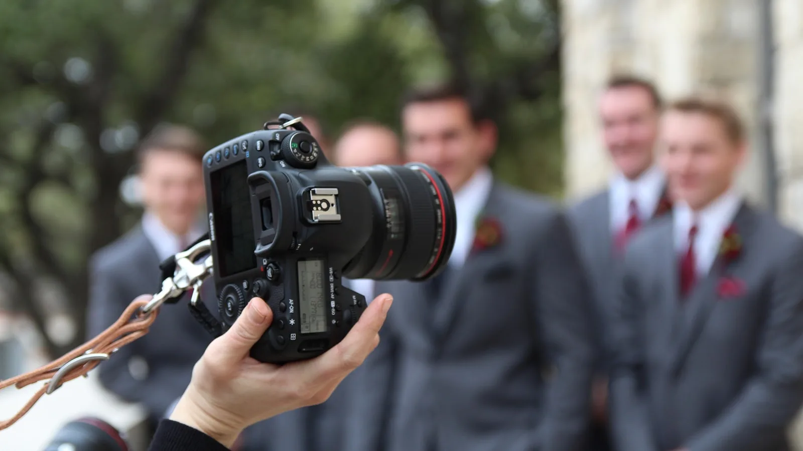 Invitat fotografiază oaspeți de nuntă, cadru peste umăr, aparatul în mână, nu un studio de produs