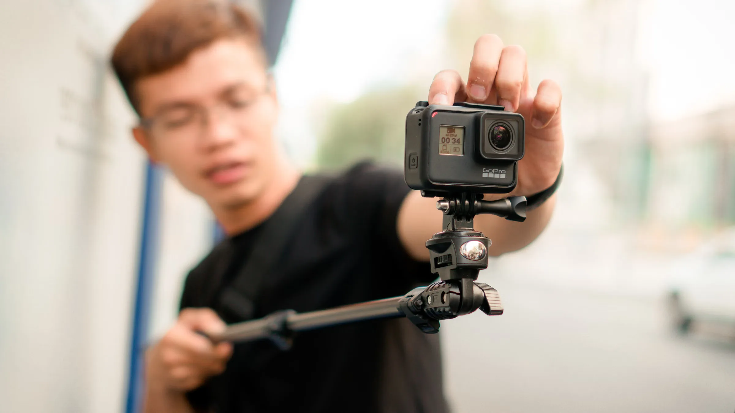 Cameră de acțiune pe monopied ținut în mână, filmare mobilă pe stradă