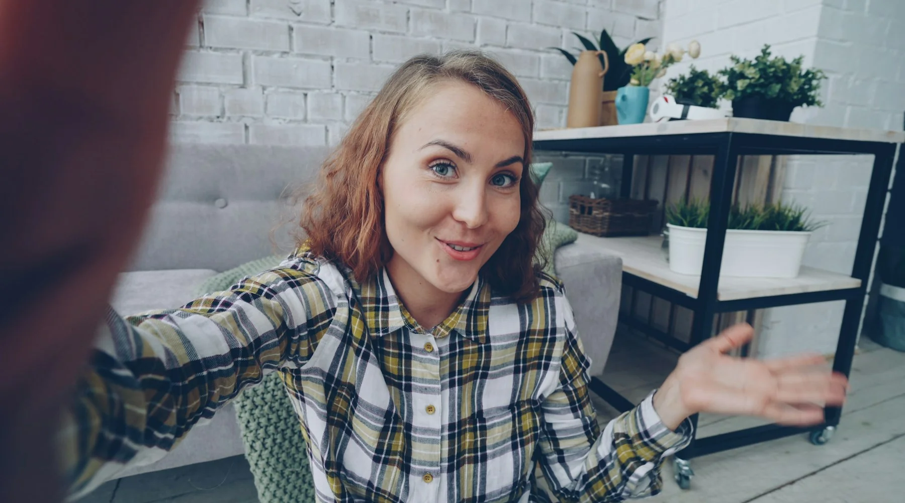 Femeie filmează un clip vertical pe telefon, în cameră, ținut în mână