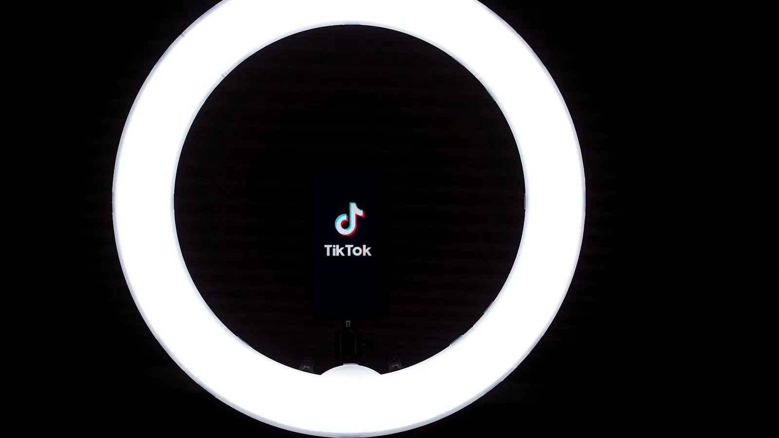 Telefon ținut în mijlocul unui inel LED aprins, treabă de ring light pe telefon