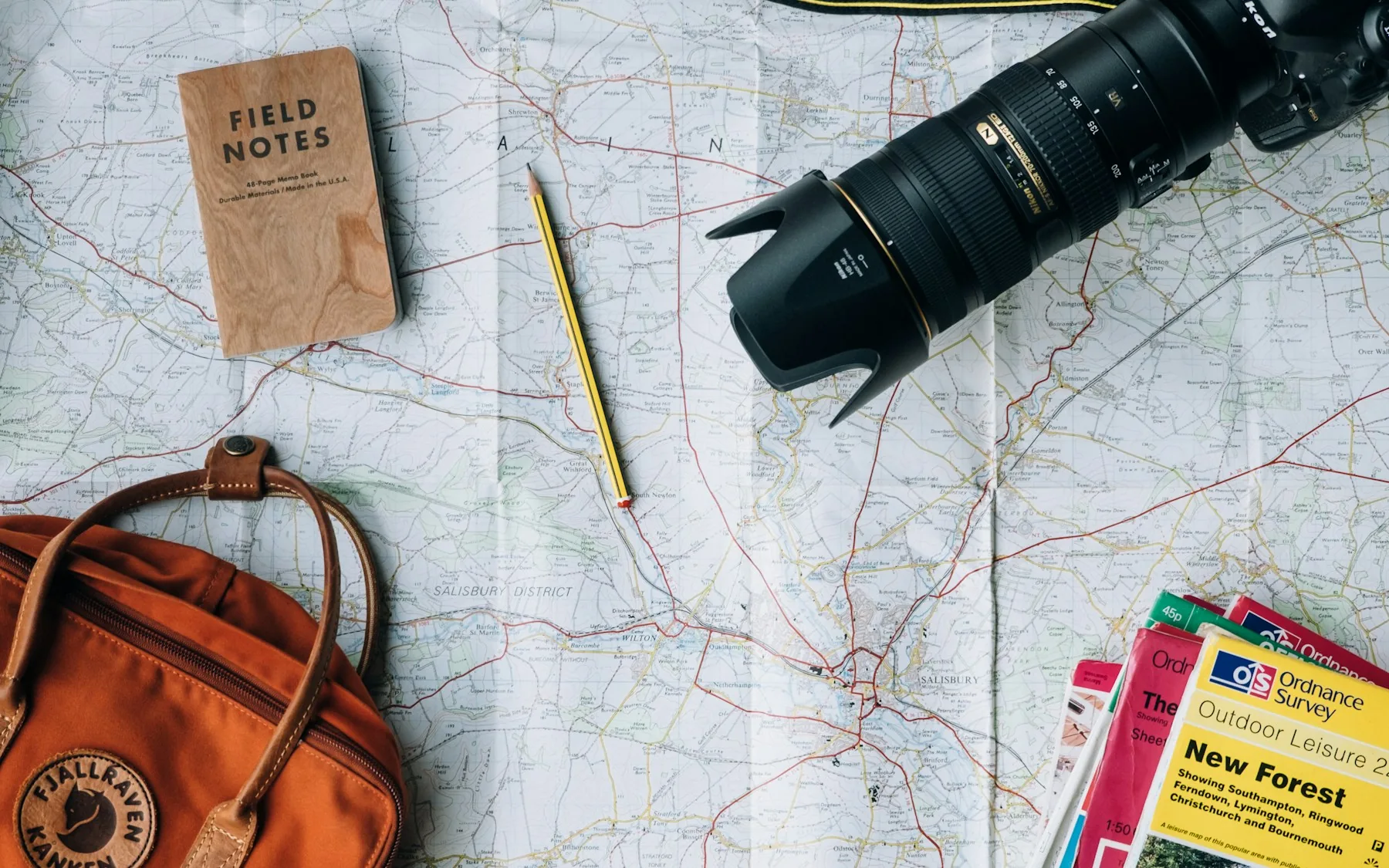 Geantă de travel cu curea, mini-trepied și huse pe un pervaz, kit foto de drum